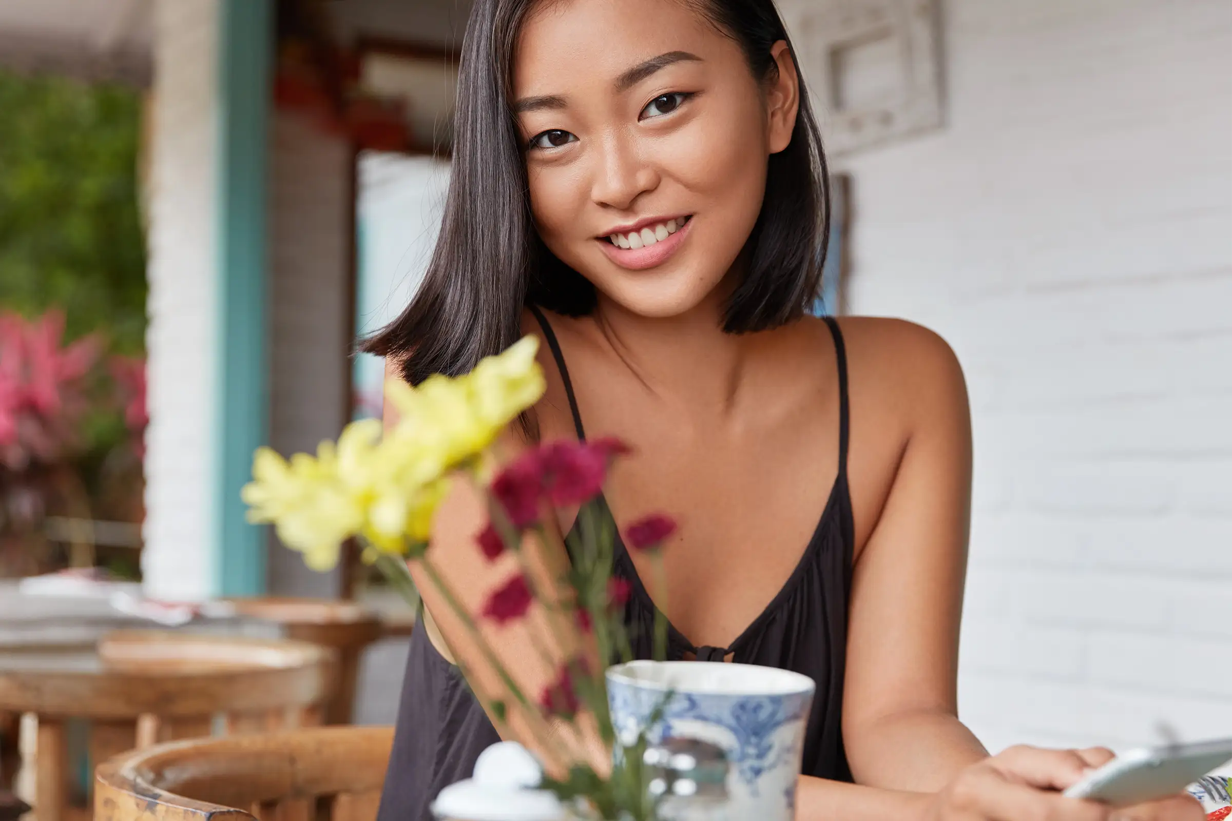 A beautiful woman at a table with flowers